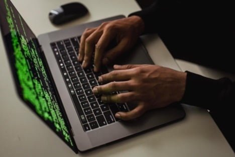 Malware realiza alterações no computador para impedir que você tenha acesso. Fonte: https://www.pexels.com/pt-br/foto/corte-o-sistema-de-hacking-ciberespiao-enquanto-digita-no-laptop-5935794/
